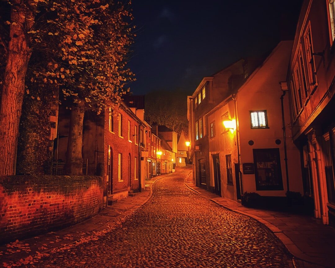 Foggy cobblestone street in an old European town at night