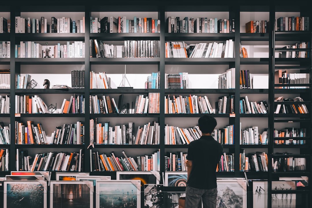 Portrait of a Croatian male author standing among bookshelves in a library