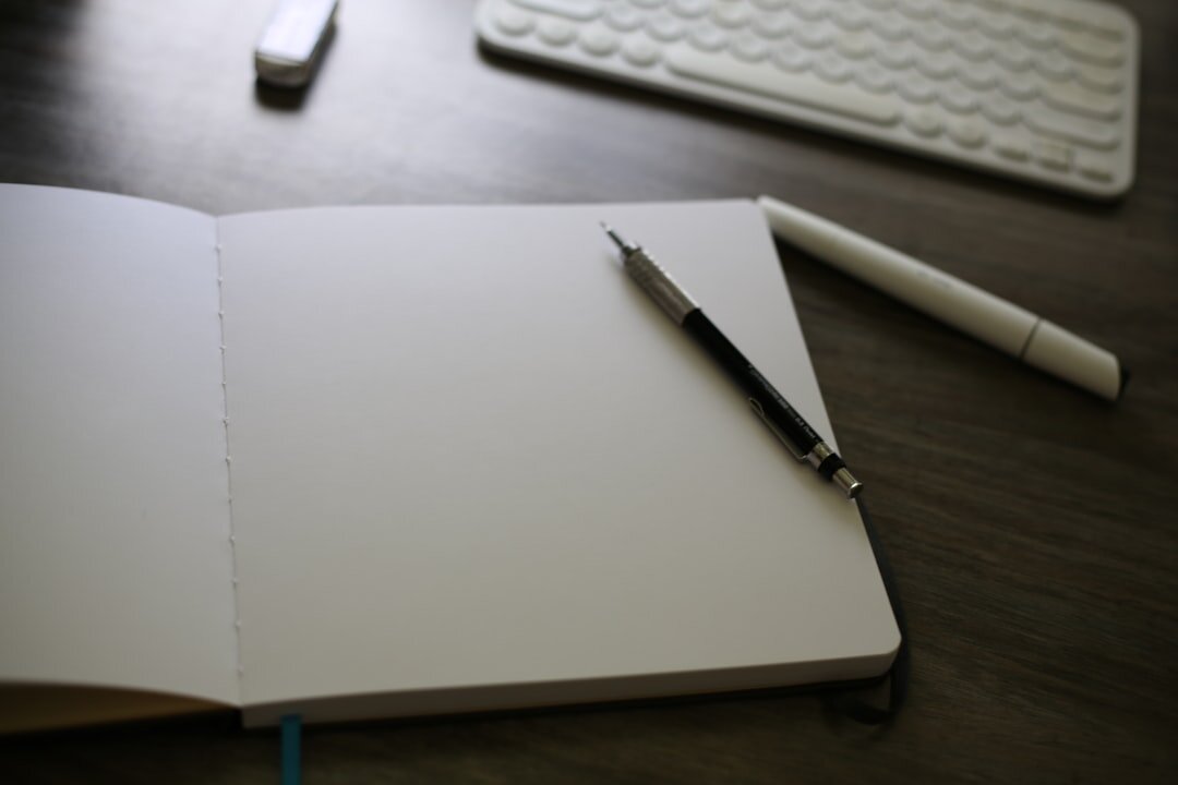 Open notebook with a pen and cup of coffee on a wooden table